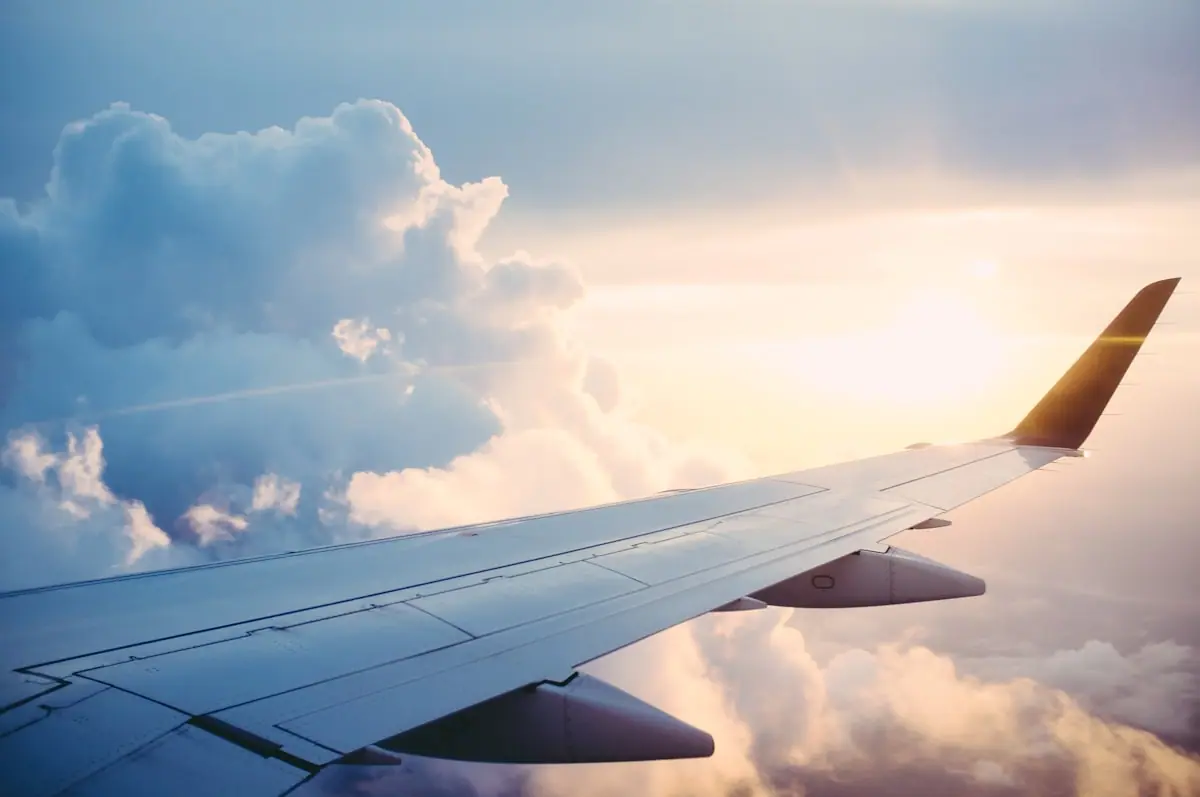 Commercial jet aircraft in flight above clouds, illustrating Delta Air Lines and Berkshire Hathaway's renewed airline equity stake.