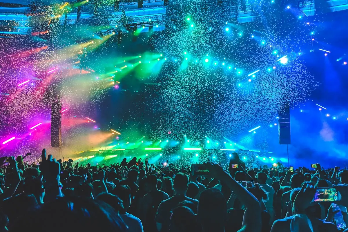 Arena crowd under stage lights suggesting major-label streaming rollouts—not official artwork for the named releases.