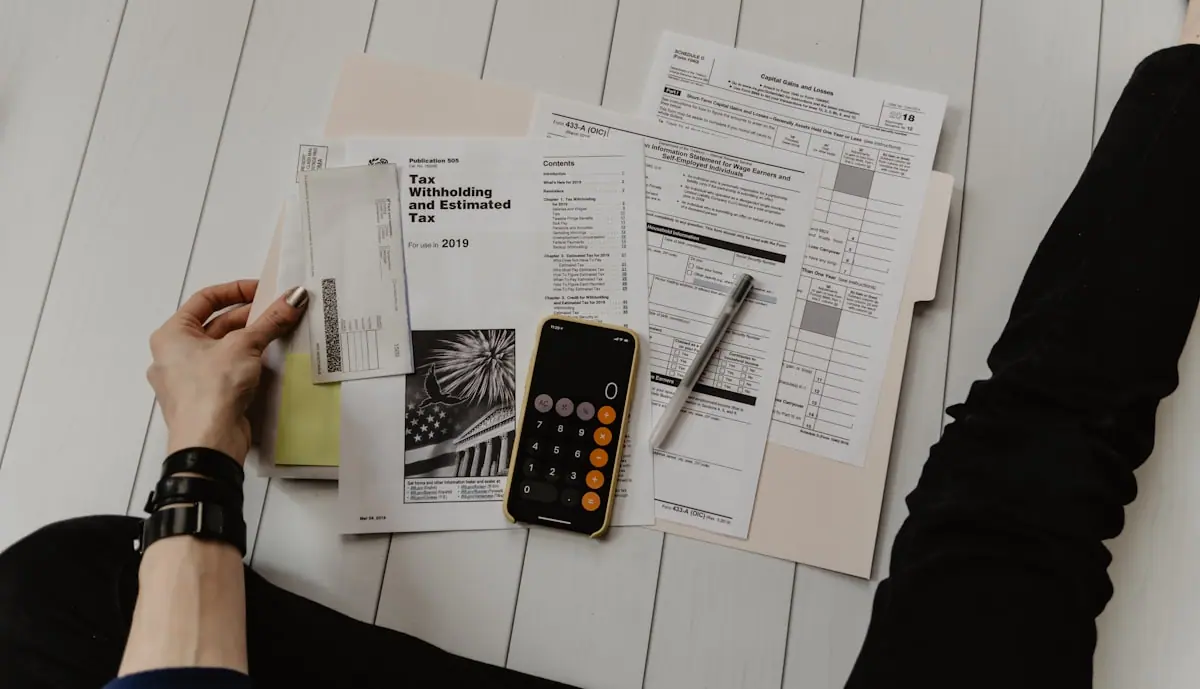 A calculator and financial documents, representing the urgency of filing late tax returns to avoid HMRC penalties.